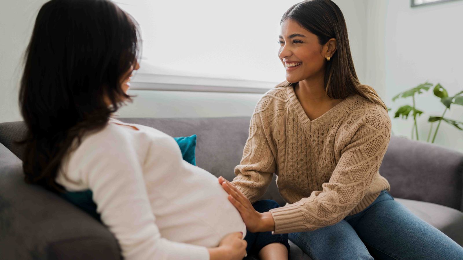 Two women talking, one is visibly pregnant