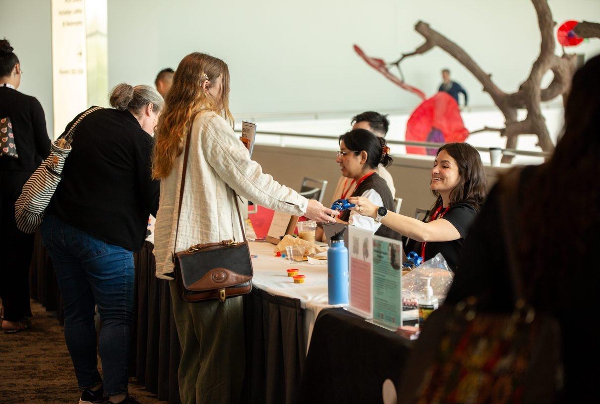 People at an information table at a conference