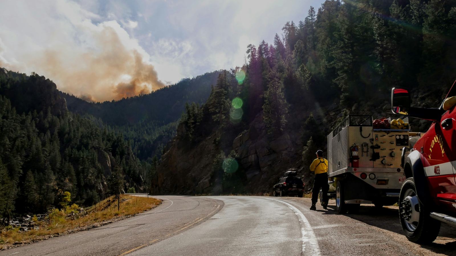 Fire crew on a roadside, smoke in the distance