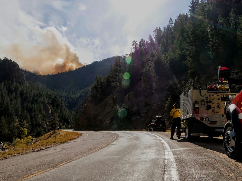 Fire crew on a roadside, smoke in the distance