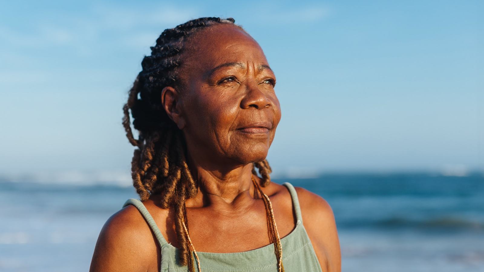 Pensive woman on beach at sunset
