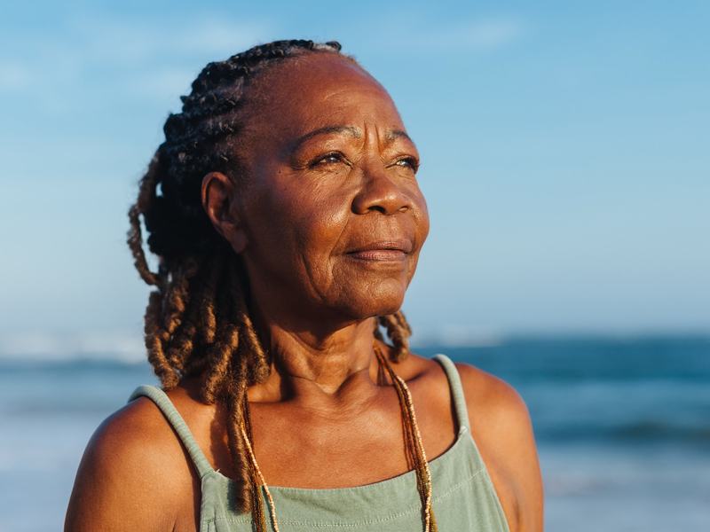 Pensive woman on beach at sunset